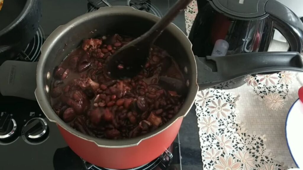 Finalizando o processo de colocar os ingredientes de ajuste da feijoada.